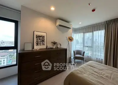 Modern bedroom with city view, featuring elegant decor and ample natural light.
