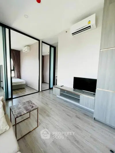 Modern living room with sleek design and air conditioning, featuring a TV and stylish coffee table.