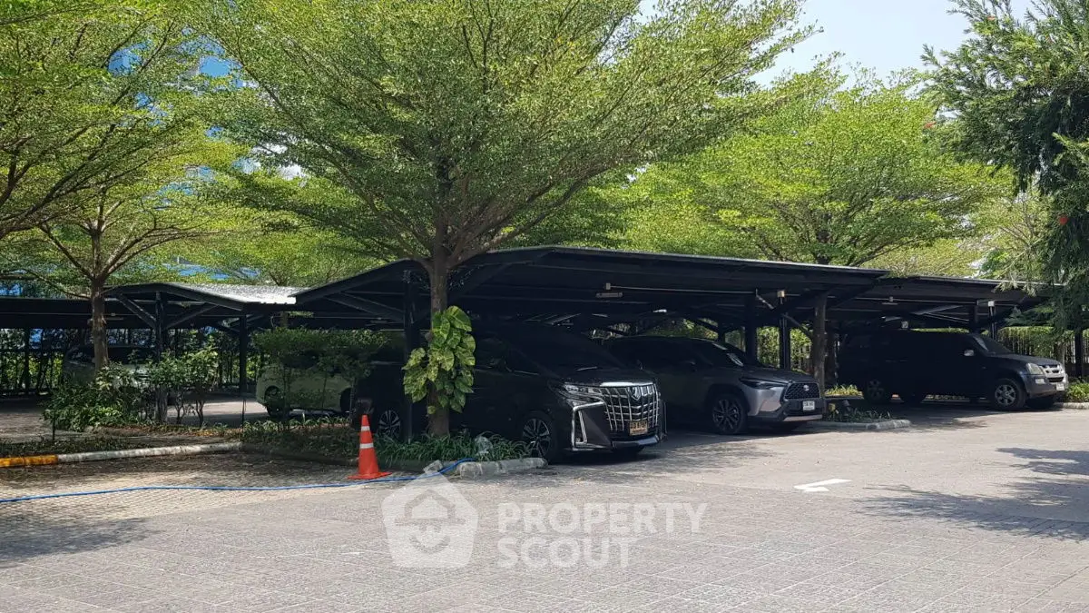 Spacious parking area with lush greenery and modern carports
