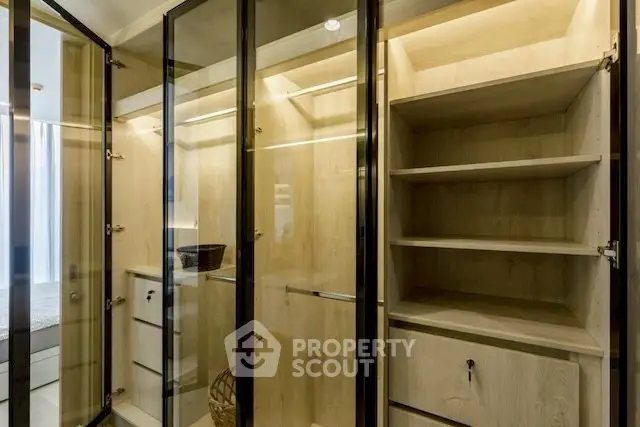 Luxurious walk-in closet with glass doors and ample shelving
