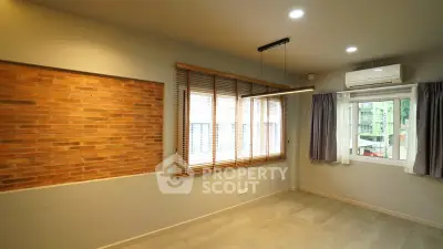 Modern room with brick accent wall, large window, and air conditioning unit.