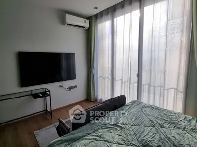 Modern bedroom with large window and wall-mounted TV, featuring sleek design and natural light.
