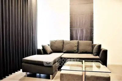 Modern living room with sleek black sofa and glass coffee table, perfect for stylish urban living.