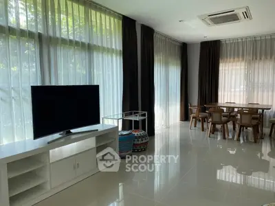 Spacious living room with modern decor and large windows offering natural light.