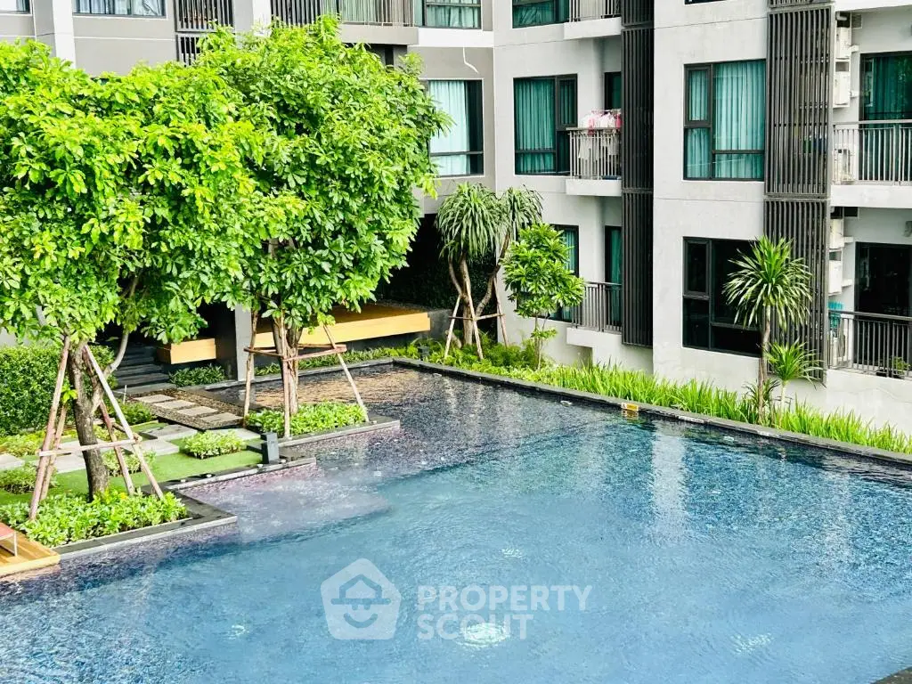 Luxurious apartment complex with serene pool and lush greenery, perfect for relaxation and modern living.
