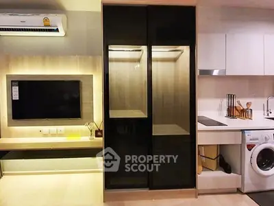 Modern apartment interior with sleek kitchen and living area featuring built-in appliances and stylish decor.