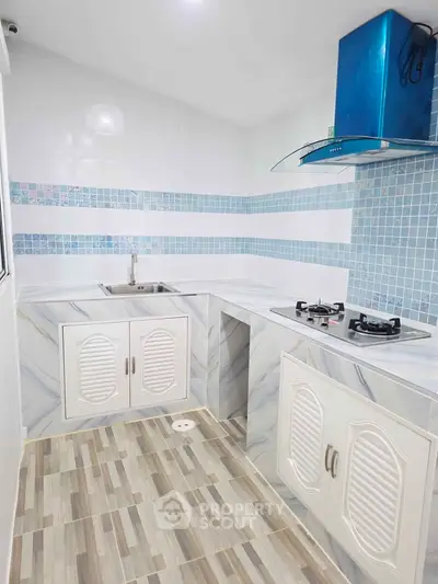 Modern kitchen with blue accents and gas stove in a compact layout