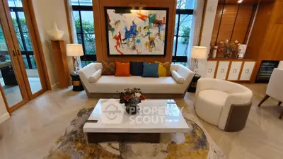 Luxurious living room with modern art, elegant furniture, and large windows for natural light.