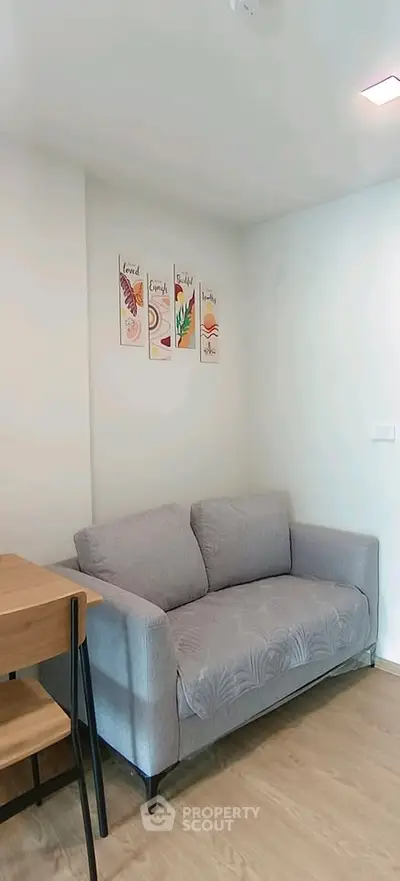 Cozy living room with modern gray sofa and stylish wall art, perfect for relaxation.