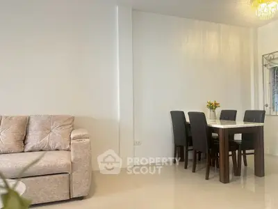 Modern living room with cozy sofa and elegant dining area in open layout.