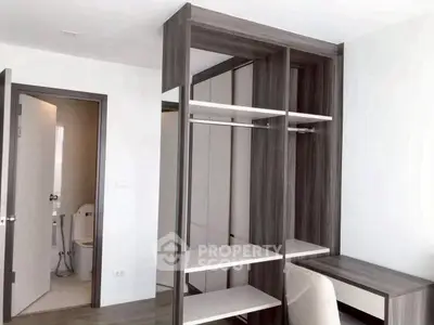 Modern bedroom with sleek wardrobe and study desk, featuring minimalist design and neutral tones.