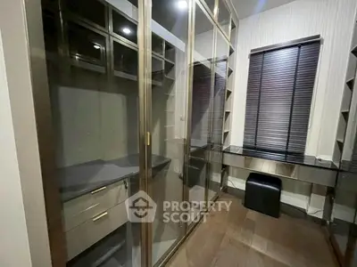 Luxurious walk-in closet with sleek glass doors and modern design