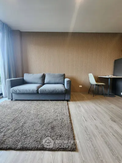 Modern living room with stylish sofa and dining area, featuring elegant wood paneling and cozy carpet.