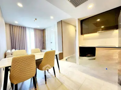 Modern dining area with elegant chairs and open kitchen layout in a stylish apartment.