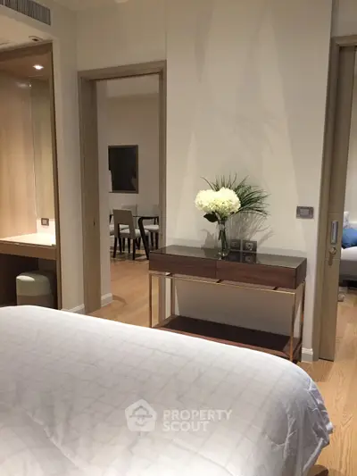Modern bedroom with elegant decor and view into dining area