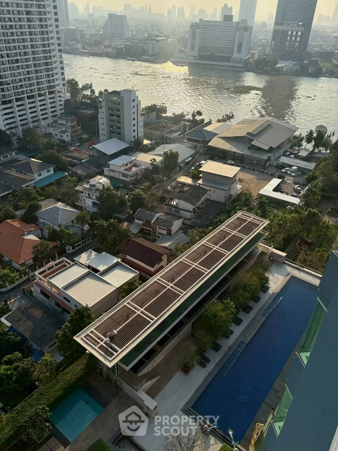 Stunning aerial view of riverside cityscape with modern pool and lush greenery