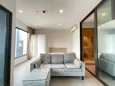 Modern living room with large windows and cozy gray sofa in a stylish apartment.
