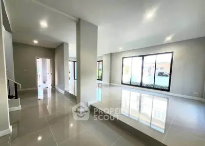 Spacious modern living room with large windows and glossy tiled floors