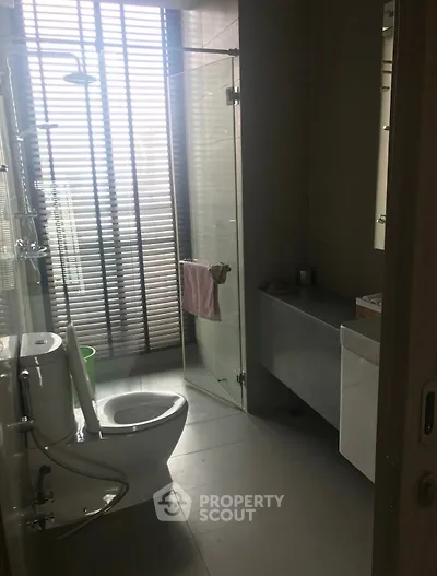 Modern bathroom with glass shower and sleek fixtures in a contemporary apartment.