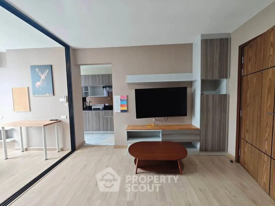 Modern living room with sleek furniture and open kitchen layout in a stylish apartment.