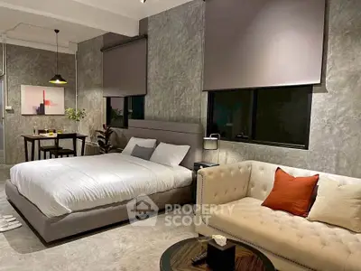 Modern bedroom with stylish decor, featuring a cozy bed, elegant sofa, and dining area in an open layout.