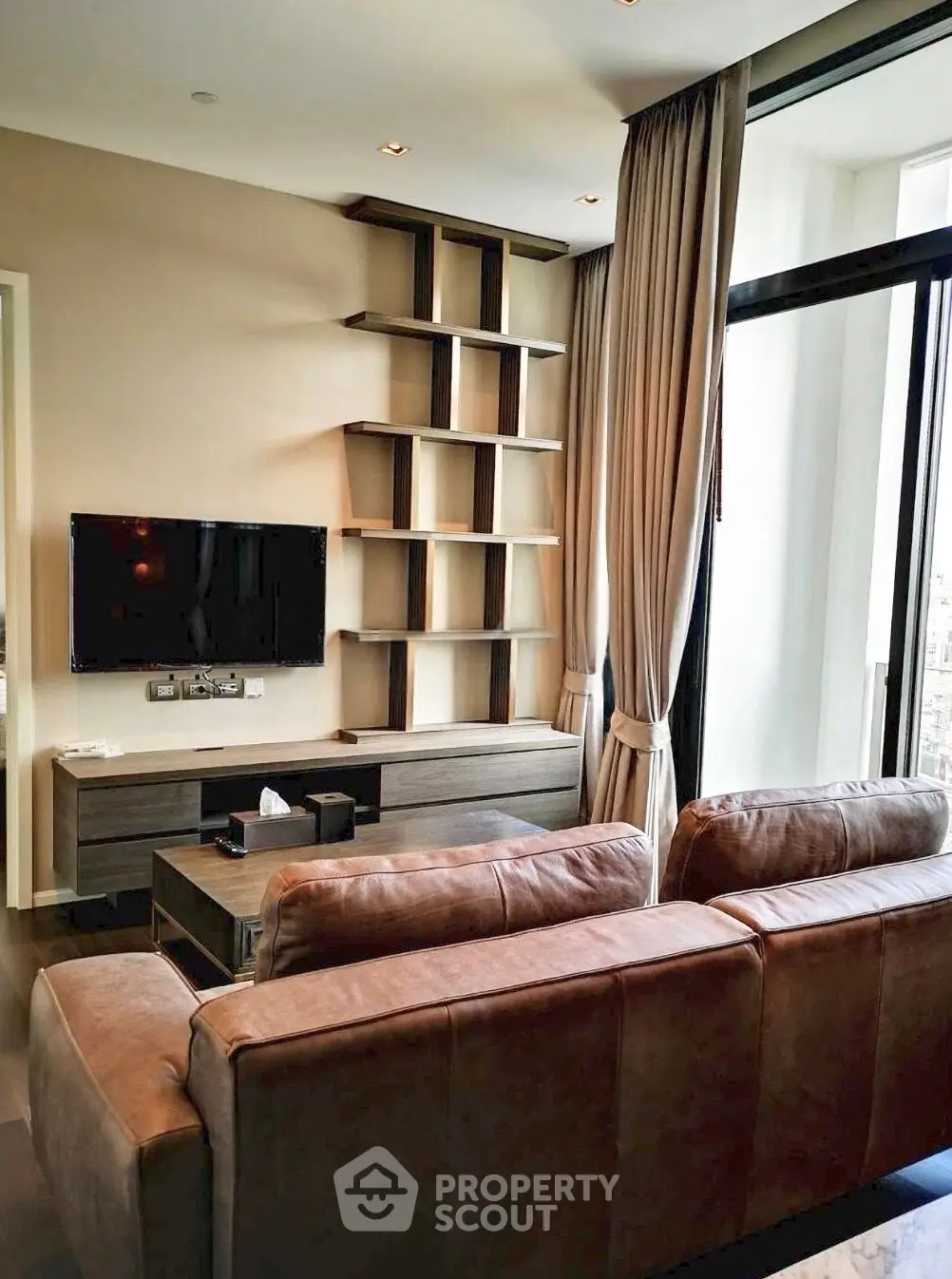 Modern living room with stylish shelving and large windows for natural light.