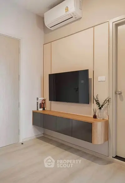 Modern living room with wall-mounted TV and sleek air conditioning unit.