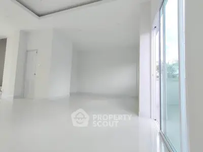 Spacious empty room with large windows and glossy white flooring