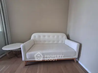 Modern minimalist living room with stylish white sofa and wooden floor.