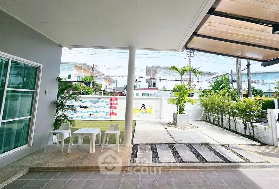 Charming outdoor patio with modern furniture and lush greenery, perfect for relaxation and entertaining.