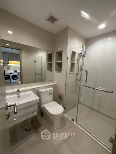 Modern bathroom with glass shower and sleek fixtures in a contemporary apartment.
