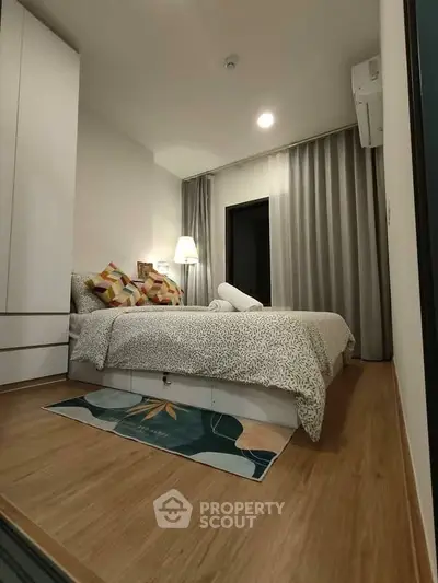 Cozy bedroom with modern decor and wooden flooring in a stylish apartment.