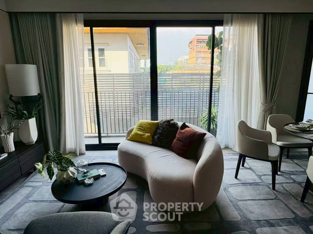 Stylish living room with modern furniture and large windows offering natural light.