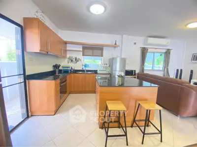 Spacious open-layout kitchen with modern appliances and cozy living area, perfect for entertaining.