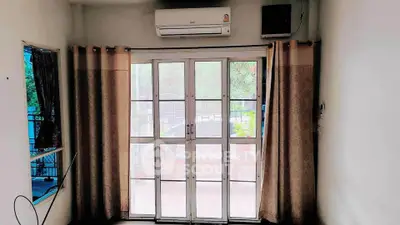 Cozy room with large window and air conditioning, perfect for natural light and comfort.