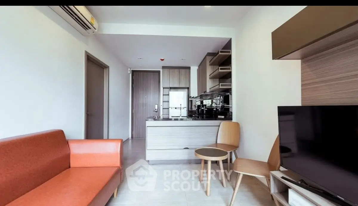 Modern living room with sleek furniture and open kitchen layout in a stylish apartment.