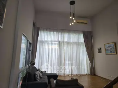 Spacious living room with high ceilings and large windows for natural light.
