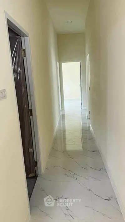 Bright hallway with marble flooring leading to open living space