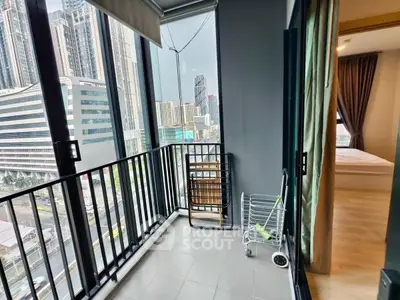 Modern high-rise apartment with balcony offering stunning city views and direct bedroom access.