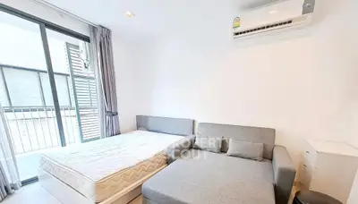 Modern bedroom with bed, sofa, and air conditioning in bright apartment