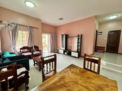 Spacious living room with elegant wooden furniture and natural light, perfect for family gatherings.