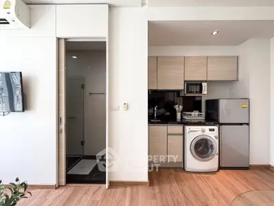 Modern apartment interior with compact kitchen and washing machine