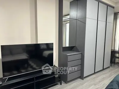 Modern bedroom with sleek wardrobe and flat-screen TV, perfect for urban living.