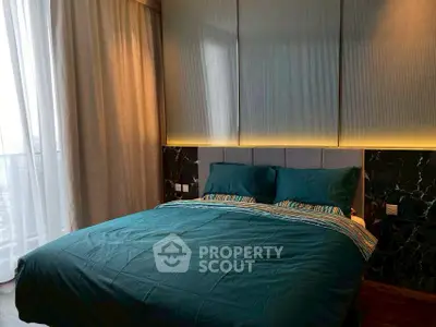 Modern bedroom with stylish decor and large window for natural light.