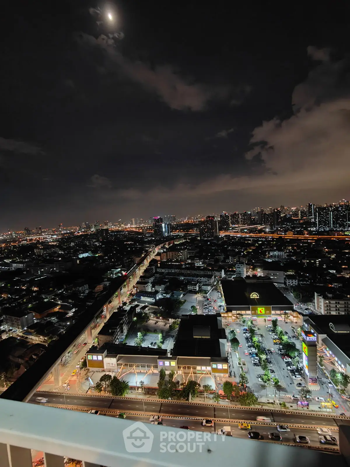 Stunning cityscape night view from high-rise balcony with vibrant city lights.