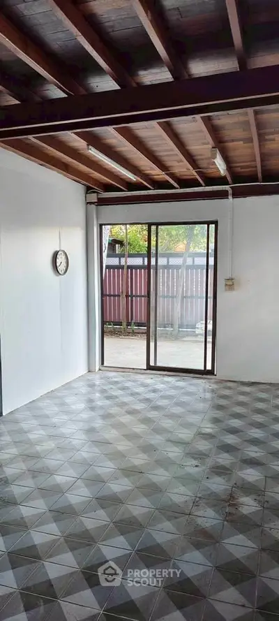 Spacious room with tiled floor and sliding glass door leading to outdoor area, perfect for customization.