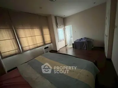 Cozy bedroom with large windows and soft lighting, perfect for relaxation and comfort.