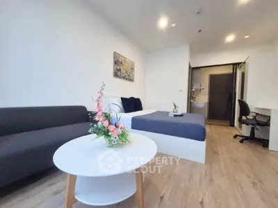 Modern studio apartment with cozy bed, stylish sofa, and elegant decor
