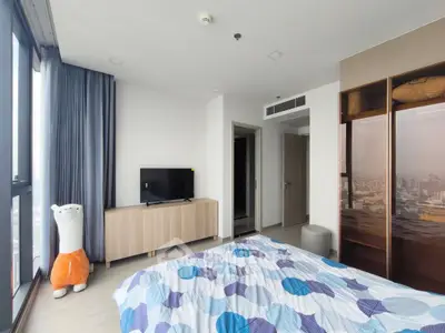 Spacious bedroom with city view, modern decor, and ample natural light.