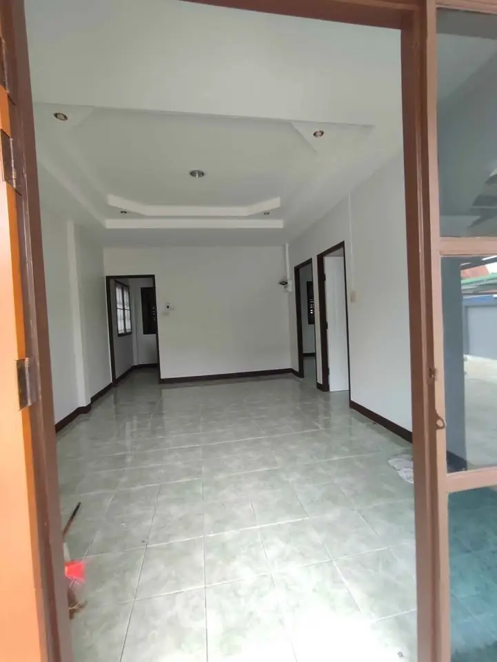 Spacious empty room with tiled floor and recessed ceiling lights